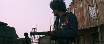 Movie still from “The Specialists” (1969), directed by Sergio Corbucci – A man holding a rifle in front of a construction site; Medium shot, Low angle