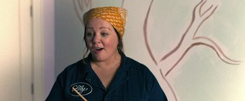 Movie still from “The Starling” (2021), directed by Theodore Melfi – A woman wearing a head scarf is holding a paintbrush in her mouth; Close Up shot, Over the shoulder angle