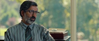 Movie still from “The Starling” (2021), directed by Theodore Melfi – A person wearing glasses and a tie; Close Up shot, Over the shoulder angle