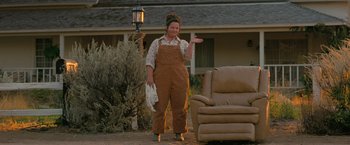Movie still from “The Starling” (2021), directed by Theodore Melfi – A woman standing in front of a chair and a couch; Wide shot, High angle