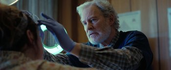 Movie still from “The Starling” (2021), directed by Theodore Melfi – An older man sitting in front of a window; Medium shot, Low angle