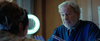 Movie still from “The Starling” (2021), directed by Theodore Melfi – An older man holding a ring light in front of a mirror; Close Up shot, Over the shoulder angle