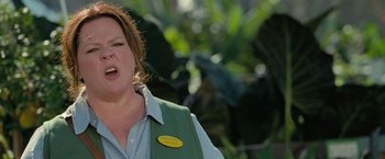 Movie still from “The Starling” (2021), directed by Theodore Melfi – A woman in a green vest is standing in front of a tree; Close Up shot, Low angle