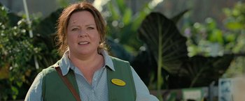 Movie still from “The Starling” (2021), directed by Theodore Melfi – A woman in a green vest standing in front of some plants; Close Up shot, Over the shoulder angle