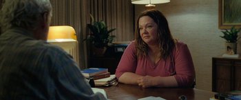 Movie still from “The Starling” (2021), directed by Theodore Melfi – A woman sitting at a table in front of a stack of books; Medium shot, Over the shoulder angle
