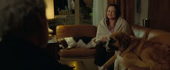 Movie still from “The Starling” (2021), directed by Theodore Melfi – A woman sitting on a couch with two dogs; Wide shot, High angle