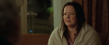 Movie still from “The Starling” (2021), directed by Theodore Melfi – A person sitting on a couch with a blanket; Close Up shot, Over the shoulder angle