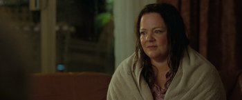 Movie still from “The Starling” (2021), directed by Theodore Melfi – A person sitting on a couch with a blanket; Close Up shot, Over the shoulder angle