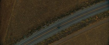 Movie still from “The Starling” (2021), directed by Theodore Melfi – An aerial view of a car driving down a road; Extreme Wide shot, Overhead angle