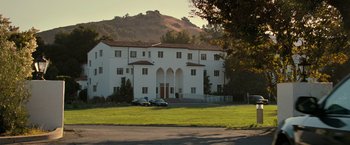 Movie still from “The Starling” (2021), directed by Theodore Melfi – A large white building sitting on top of a green field; Extreme Wide shot, Low angle