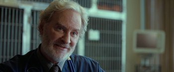 Movie still from “The Starling” (2021), directed by Theodore Melfi – An older man wearing a suit and tie; Close Up shot, Over the shoulder angle