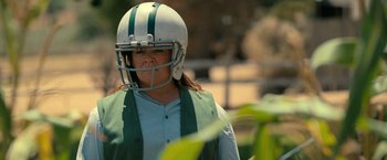 Movie still from “The Starling” (2021), directed by Theodore Melfi – A woman wearing a football helmet in a field; Medium shot, Over the shoulder angle