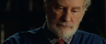 Movie still from “The Starling” (2021), directed by Theodore Melfi – An older man with a beard and a red tie; Close Up shot, Over the shoulder angle