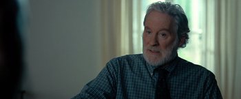 Movie still from “The Starling” (2021), directed by Theodore Melfi – An older man wearing a plaid shirt and a black tie; Close Up shot, Over the shoulder angle