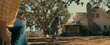 Movie still from “The Starling” (2021), directed by Theodore Melfi – A man is playing with a frisbee in a field; Extreme Wide shot, Low angle