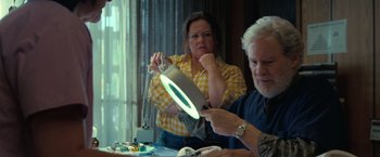 Movie still from “The Starling” (2021), directed by Theodore Melfi – A woman and a man working on a project; Medium shot, High angle