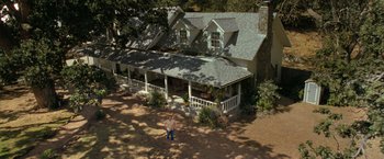 Movie still from “The Starling” (2021), directed by Theodore Melfi – An aerial view of a person standing in front of a house; Extreme Wide shot, High angle