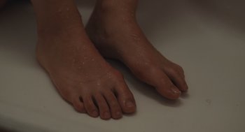 Movie still from “The Starling Girl” (2023), directed by Laurel Parmet – A person's bare feet on the ground; Extreme Close Up shot, High angle