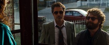 Movie still from “Due Date” (2010), directed by Todd Phillips – A man in a suit and tie looking in a mirror; Medium shot, Over the shoulder angle