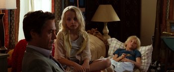 Movie still from “Due Date” (2010), directed by Todd Phillips – A young girl sitting on a couch next to an older man; Medium shot, Over the shoulder angle