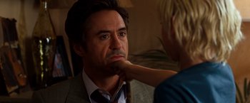 Movie still from “Due Date” (2010), directed by Todd Phillips – A man in a suit and tie is getting his face painted; Close Up shot, Over the shoulder angle