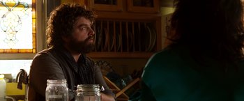 Movie still from “Due Date” (2010), directed by Todd Phillips – A man sitting at a table with a jar in front of him; Close Up shot, Over the shoulder angle