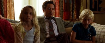 Movie still from “Due Date” (2010), directed by Todd Phillips – A man sitting on a couch next to a woman; Medium shot, Over the shoulder angle