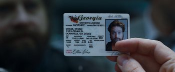 Movie still from “Due Date” (2010), directed by Todd Phillips – A person holding a driver's license in their hand; Extreme Close Up shot, Overhead angle