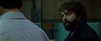 Movie still from “Due Date” (2010), directed by Todd Phillips – A man with curly hair and a beard looking at himself in the mirror; Close Up shot, Over the shoulder angle