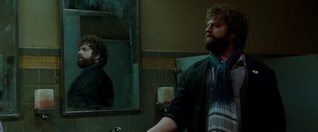 Movie still from “Due Date” (2010), directed by Todd Phillips – A man standing in front of a mirror in a bathroom; Medium shot, Low angle