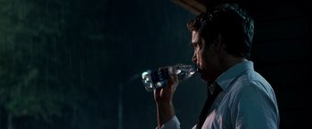 Movie still from “Due Date” (2010), directed by Todd Phillips – A man in a white dress shirt and tie drinking water; Close Up shot, Over the shoulder angle