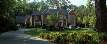 Movie still from “Due Date” (2010), directed by Todd Phillips – A large red brick house with a car parked in front of it; Extreme Wide shot, High angle