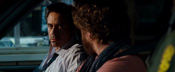 Movie still from “Due Date” (2010), directed by Todd Phillips – A man in a white dress shirt and tie next to another man in a pink shirt; Close Up shot, Over the shoulder angle