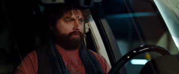 Movie still from “Due Date” (2010), directed by Todd Phillips – A man sitting in the driver's seat of a car; Close Up shot, Over the shoulder angle