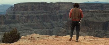 Movie still from “Due Date” (2010), directed by Todd Phillips – A man standing on top of a hill looking at a canyon; Wide shot, Over the shoulder angle