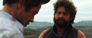 Movie still from “Due Date” (2010), directed by Todd Phillips – A man with long hair and a beard looking at another man with long hair; Close Up shot, Over the shoulder angle