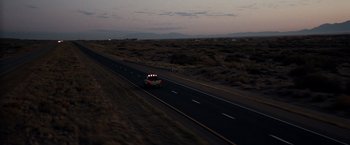 Movie still from “Due Date” (2010), directed by Todd Phillips – A car driving down a highway at night; Extreme Wide shot, High angle