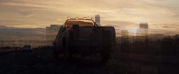 Movie still from “Due Date” (2010), directed by Todd Phillips – A pickup truck with lights on parked on the side of the road; Extreme Wide shot, Low angle