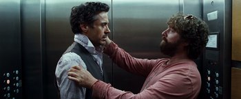 Movie still from “Due Date” (2010), directed by Todd Phillips – A man is helping another man fix his tie; Medium shot, Over the shoulder angle