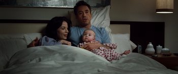 Movie still from “Due Date” (2010), directed by Todd Phillips – A man and a woman and a baby laying in a bed; Medium shot, High angle