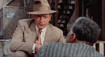 Movie still from “The Sting” (1973), directed by George Roy Hill – A man wearing a hat and a suit and a tie; Medium shot, Over the shoulder angle