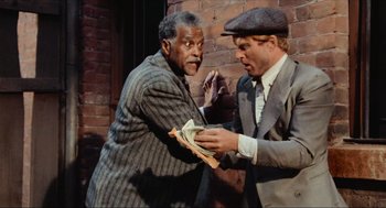 Movie still from “The Sting” (1973), directed by George Roy Hill – Two men in suits and hats are holding money; Medium shot, Low angle