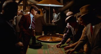 Movie still from “The Sting” (1973), directed by George Roy Hill – A group of men sitting around a roulette table; Medium shot, High angle