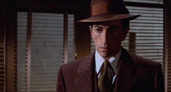 Movie still from “The Sting” (1973), directed by George Roy Hill – A person wearing a suit and a hat; Close Up shot, Low angle