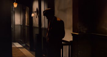 Movie still from “The Sting” (1973), directed by George Roy Hill – A man standing in the dark next to a lamp post; Wide shot, High angle