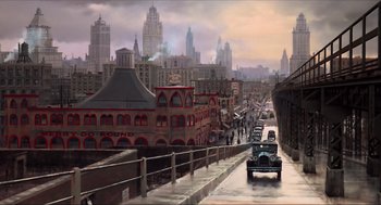 Movie still from “The Sting” (1973), directed by George Roy Hill – An oil painting of an old car driving down a street; Extreme Wide shot, High angle