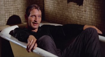 Movie still from “The Sting” (1973), directed by George Roy Hill – A man laying in a bath tub in a bathroom; Medium shot, High angle