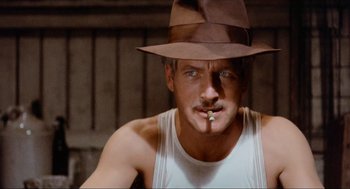Movie still from “The Sting” (1973), directed by George Roy Hill – A person wearing a hat smoking a cigarette; Close Up shot, Low angle