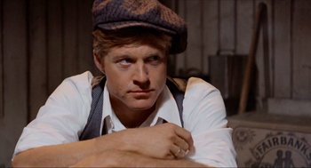 Movie still from “The Sting” (1973), directed by George Roy Hill – A person wearing a hat and looking at the camera; Close Up shot, Over the shoulder angle