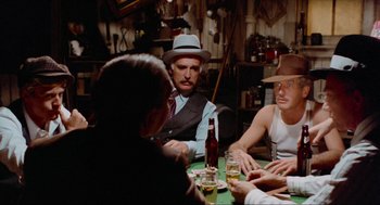 Movie still from “The Sting” (1973), directed by George Roy Hill – A group of people sitting at a table with drinks; Medium shot, Over the shoulder angle